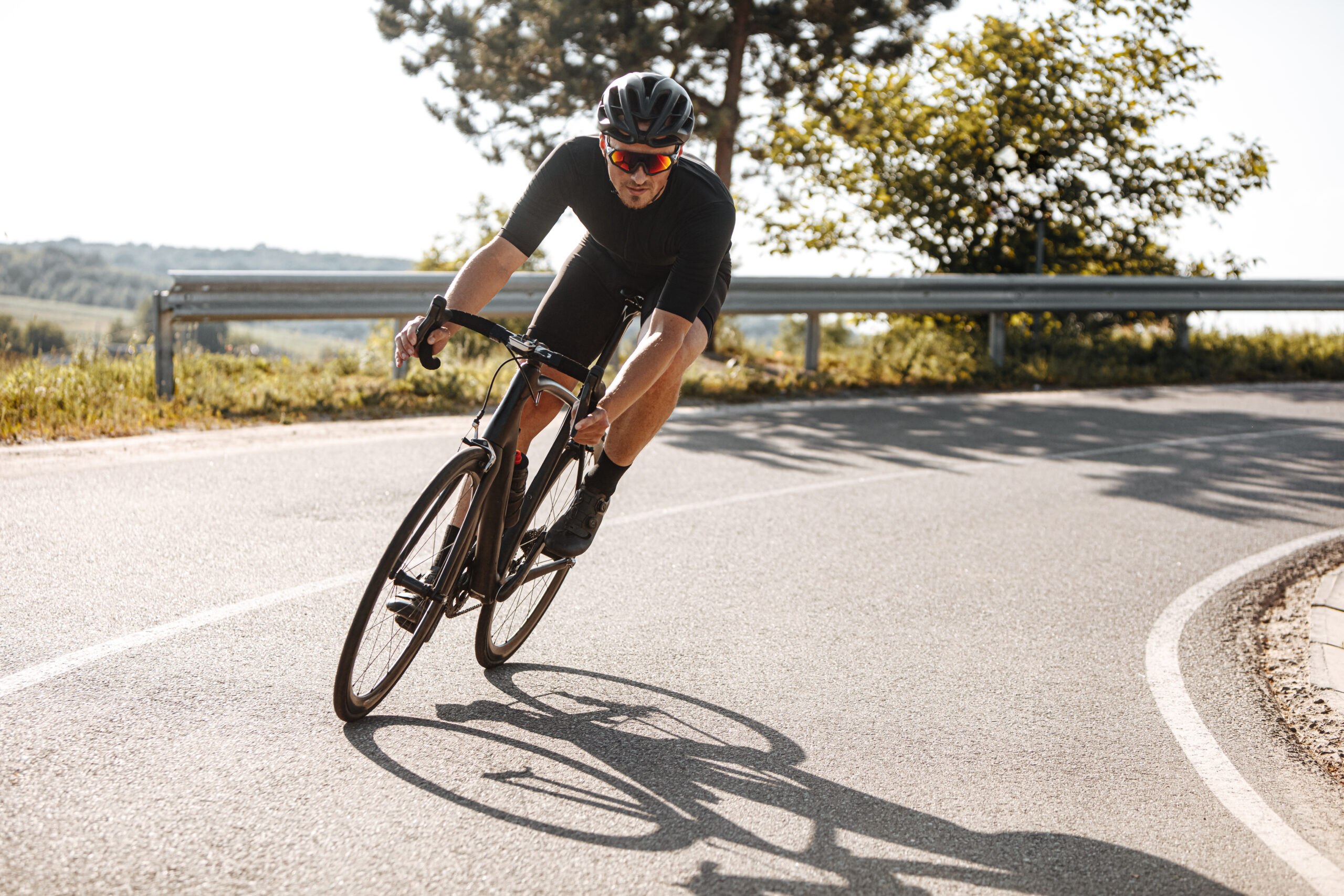 bearded-man-in-sport-clothing-riding-bike-among-countryside